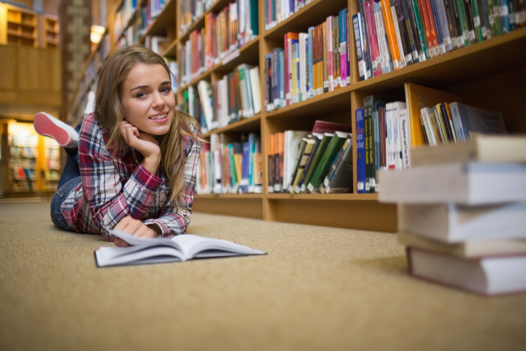 Его студентка читать. Студентка читает книги в библиотеке на полу. Студент лежит на полу в книгах русских. Блондинка в библиотеке на полу. Брюнетка в библиотеке на полу.